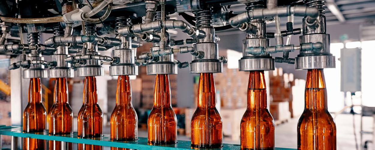 Amber beer bottles on a packaging line where nitrogen purges air before fill